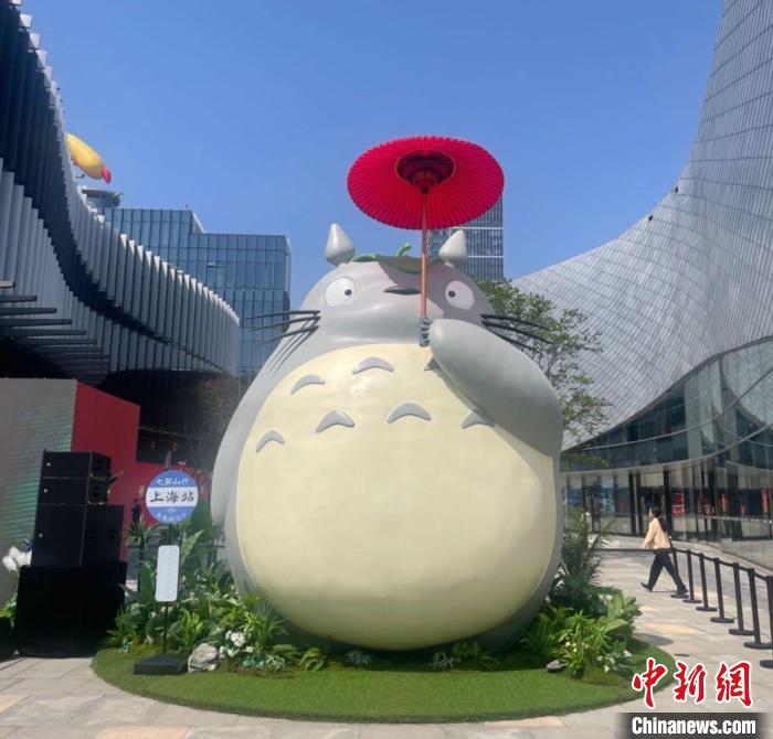 高さ6メートルのトトロは、中国蘇州風の赤い油紙を貼った傘を差し、横のバス停には「稲荷前」の代わりに「上海駅」になっている。（撮影・高凱）
