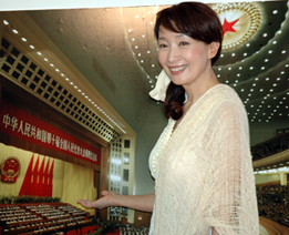 人民大会堂・万人礼堂の写真前で撮影に応じる アグネス・チャン、7月2日東京華僑会館で